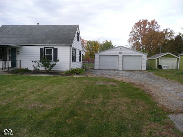 view of front of home featuring a garage, an outbuilding, and a front yard