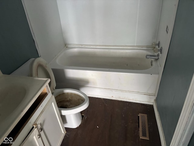 bathroom featuring hardwood / wood-style flooring, vanity, a washtub, and toilet