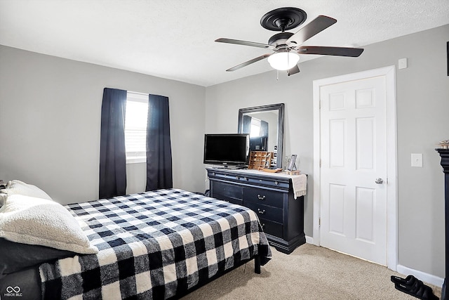 bedroom with a textured ceiling, light colored carpet, and ceiling fan