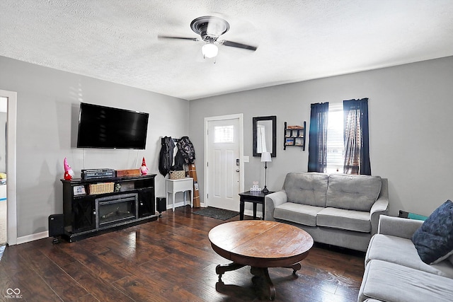 living room with ceiling fan, a textured ceiling, and dark hardwood / wood-style flooring