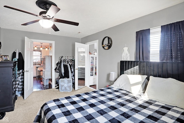 bedroom featuring ceiling fan, ensuite bathroom, and carpet flooring