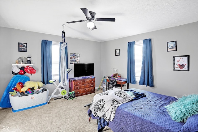 carpeted bedroom featuring a textured ceiling and ceiling fan