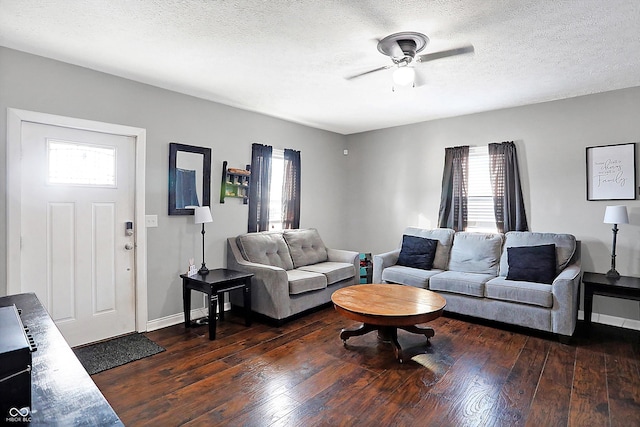 living room featuring a healthy amount of sunlight, dark hardwood / wood-style flooring, and a textured ceiling