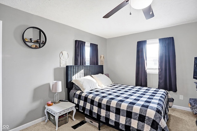 carpeted bedroom with multiple windows, a textured ceiling, and ceiling fan