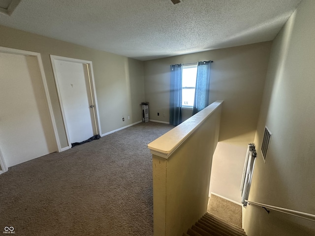 interior space with carpet flooring and a textured ceiling