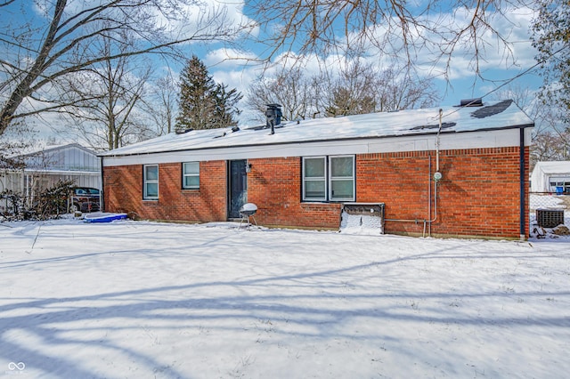snow covered house featuring central AC