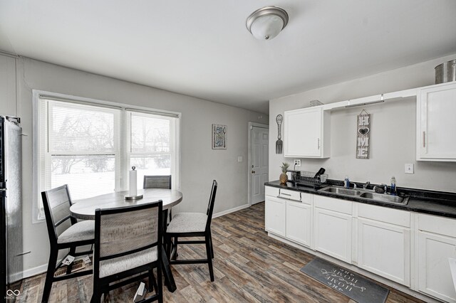 kitchen featuring dark wood-type flooring, sink, and white cabinets