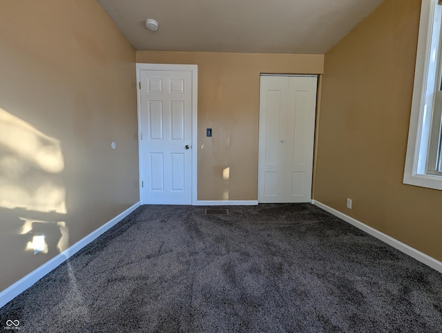 unfurnished bedroom with dark carpet