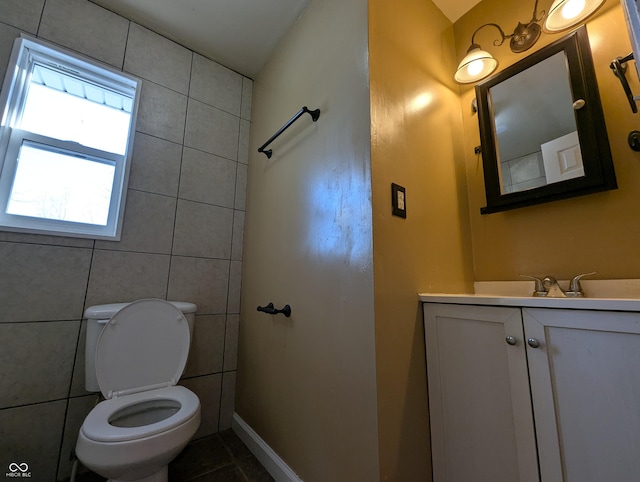 bathroom with vanity, toilet, tile patterned flooring, and tile walls