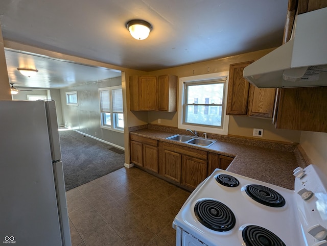 kitchen with white electric range oven, refrigerator, sink, and dark colored carpet