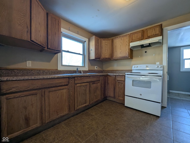 kitchen with dark tile patterned floors, plenty of natural light, and electric range