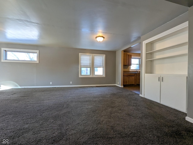 spare room with dark carpet and built in features