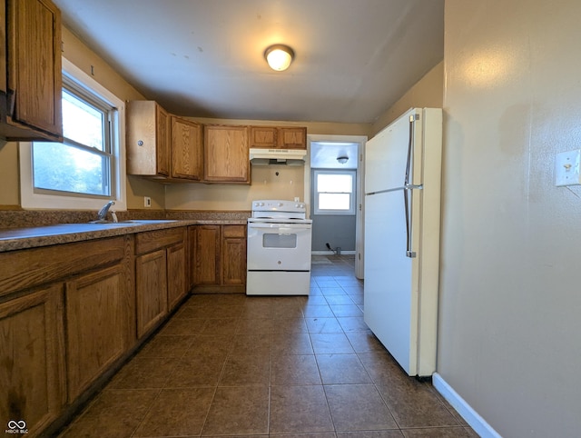 kitchen with white appliances and dark tile patterned flooring