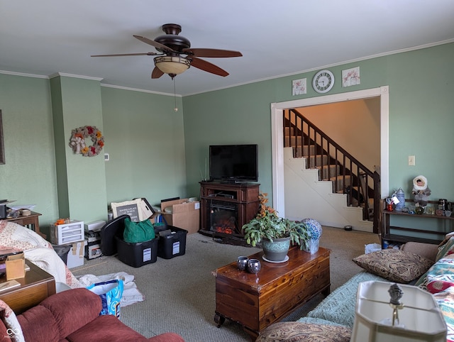 carpeted living room with ornamental molding and ceiling fan