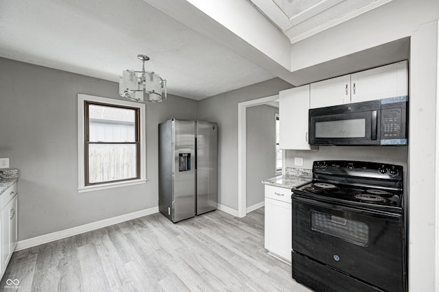 kitchen with black appliances, white cabinets, a notable chandelier, light stone counters, and light hardwood / wood-style floors