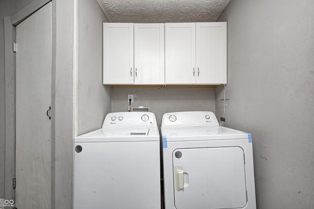 clothes washing area featuring independent washer and dryer, cabinets, and a textured ceiling