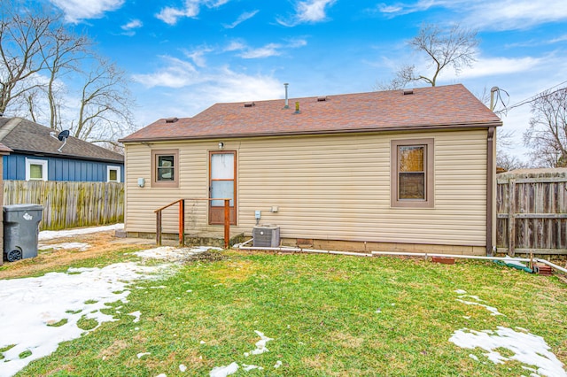 back of house with cooling unit and a yard