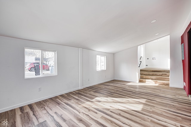 unfurnished room with vaulted ceiling and light hardwood / wood-style floors