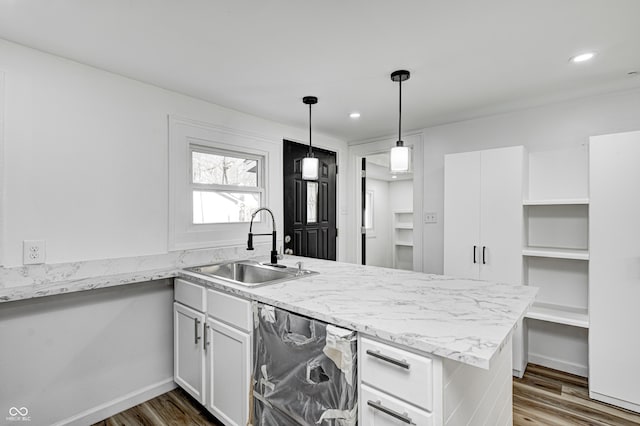 kitchen with dark hardwood / wood-style floors, kitchen peninsula, sink, and white cabinets