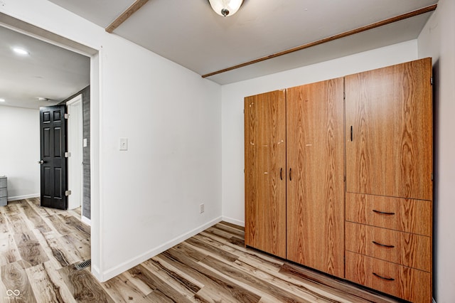 unfurnished bedroom featuring light hardwood / wood-style floors and a closet