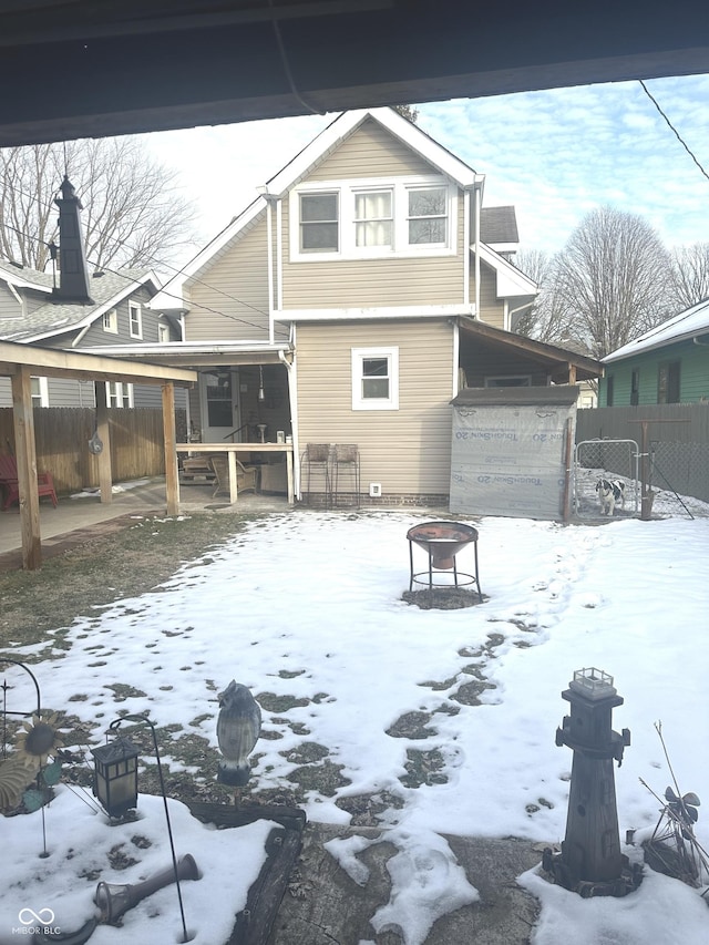 view of snow covered rear of property