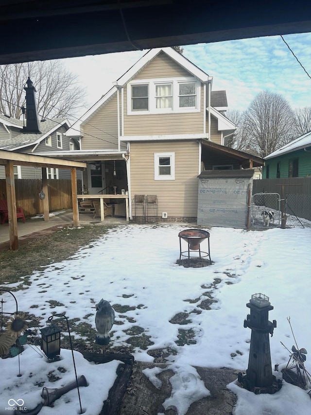 snow covered house with an outdoor fire pit