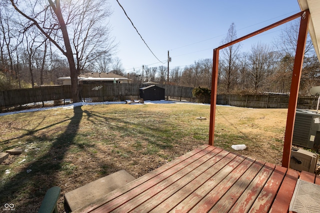 view of yard featuring cooling unit, a storage unit, and a deck