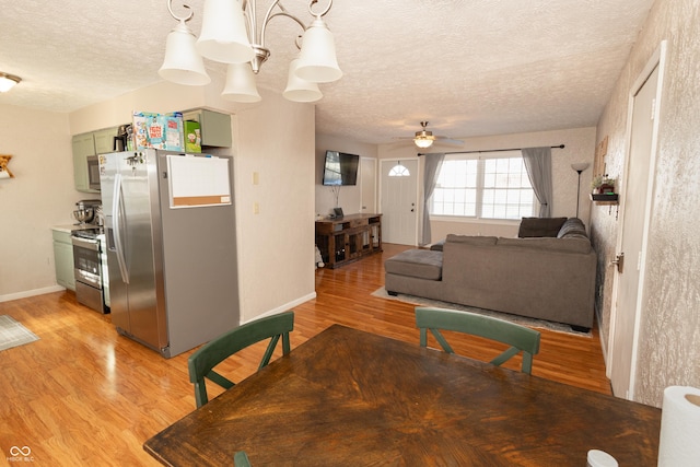 dining area featuring ceiling fan, light hardwood / wood-style floors, and a textured ceiling