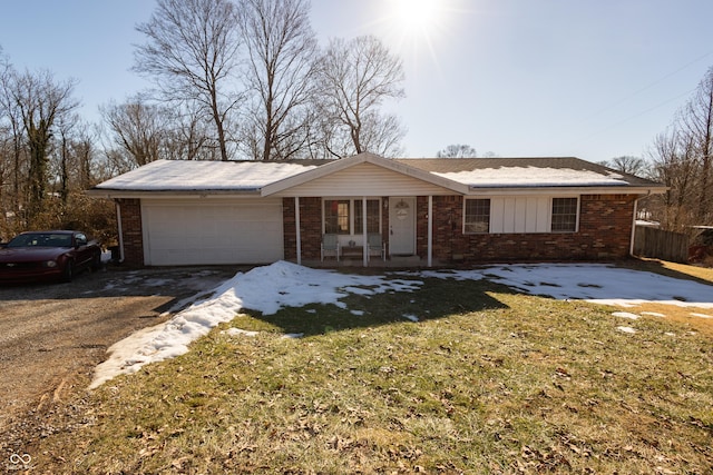 ranch-style home featuring a garage, a front yard, and covered porch