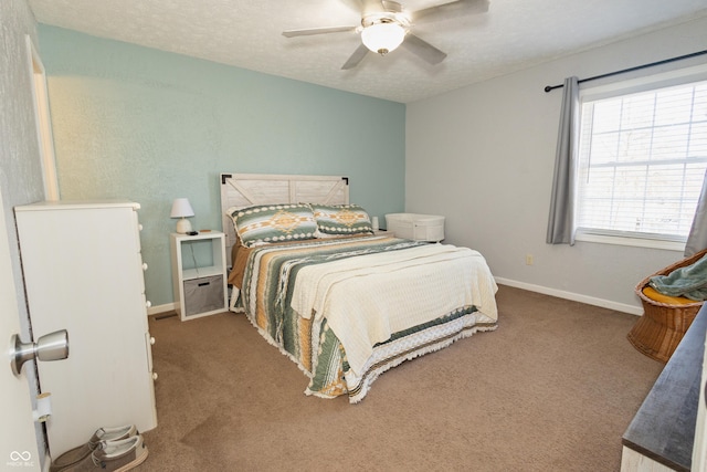 carpeted bedroom featuring ceiling fan and a textured ceiling