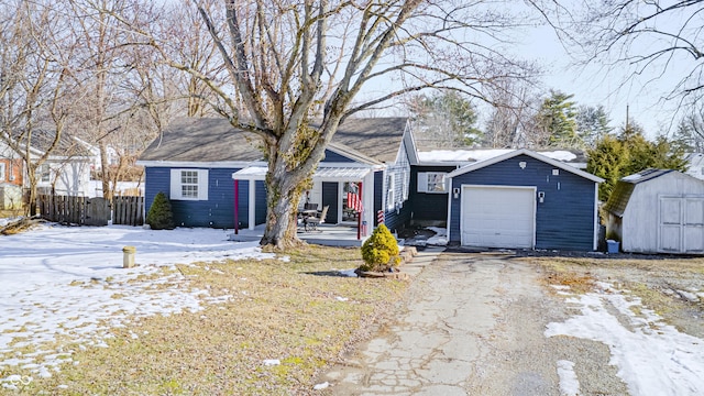 ranch-style house with an outbuilding, a storage shed, a garage, fence, and driveway