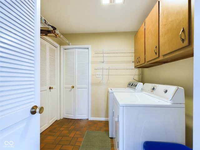 laundry room featuring separate washer and dryer and cabinets