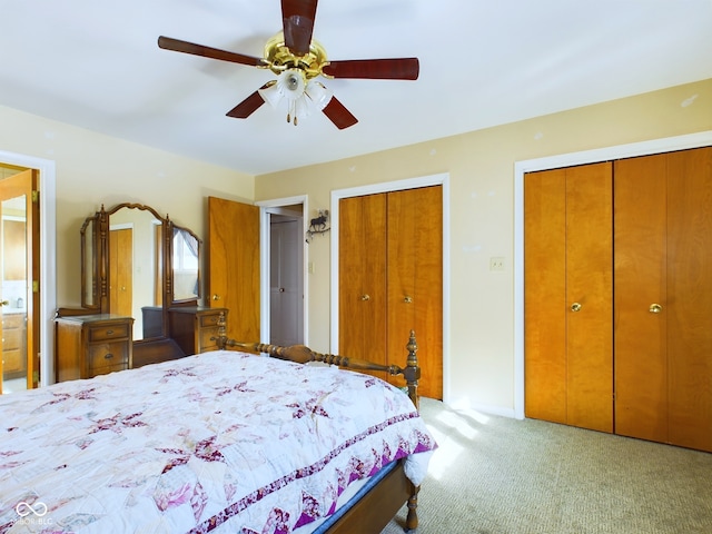 bedroom with two closets, light colored carpet, and ceiling fan