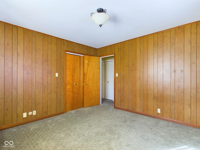 unfurnished bedroom with light colored carpet and a closet