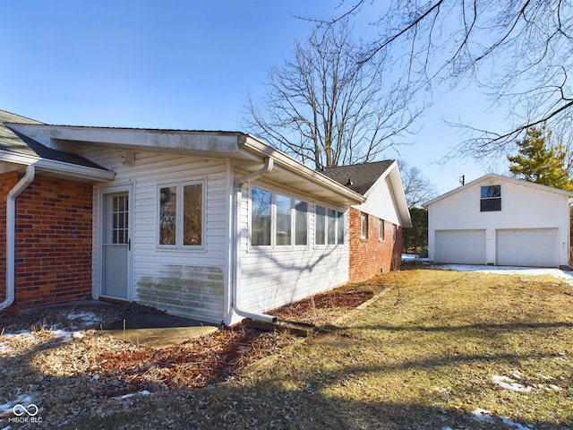 view of home's exterior with a garage, an outdoor structure, and a yard