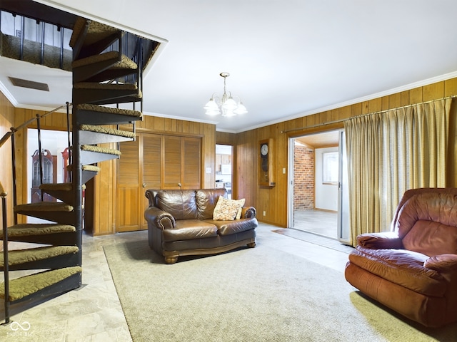 carpeted living room with a notable chandelier, crown molding, and wood walls