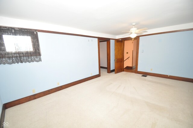 carpeted spare room featuring ceiling fan