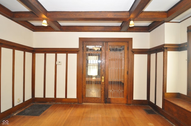 interior space with beam ceiling, coffered ceiling, and light wood-type flooring