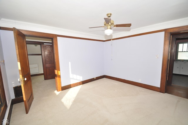 unfurnished bedroom featuring crown molding, ceiling fan, and light colored carpet