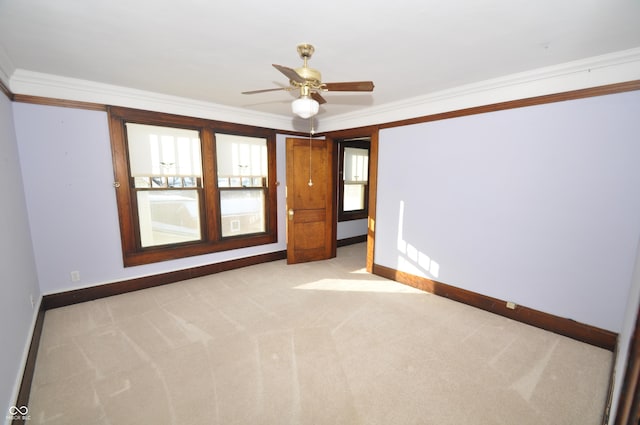 unfurnished room with light carpet, crown molding, and ceiling fan