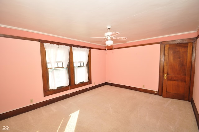 empty room featuring light carpet, ornamental molding, and ceiling fan