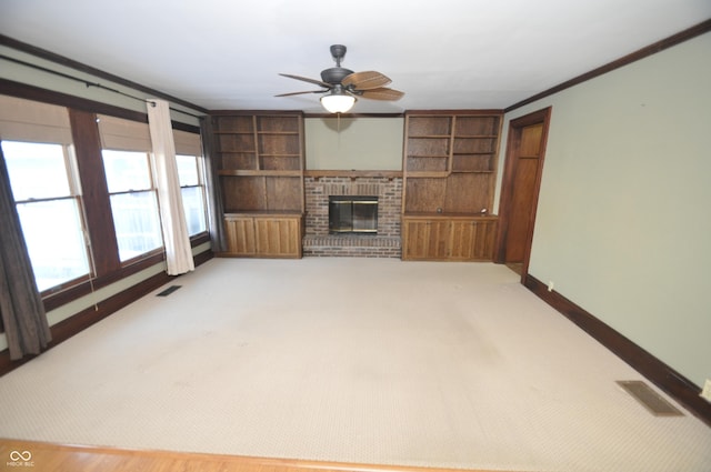 unfurnished living room featuring ornamental molding, carpet flooring, a fireplace, and built in shelves