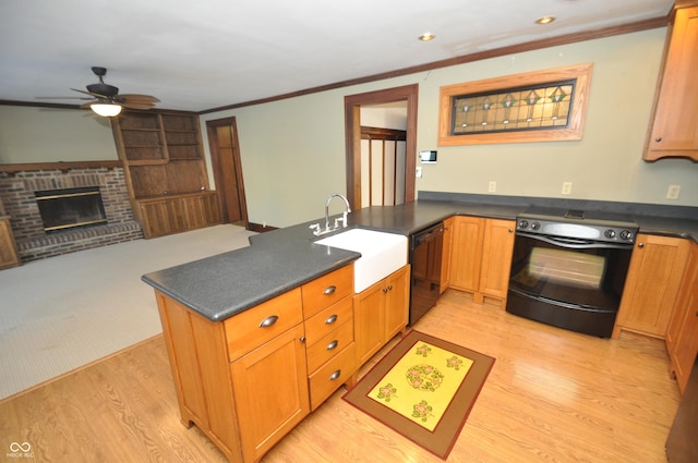 kitchen featuring sink, ornamental molding, black appliances, a brick fireplace, and kitchen peninsula