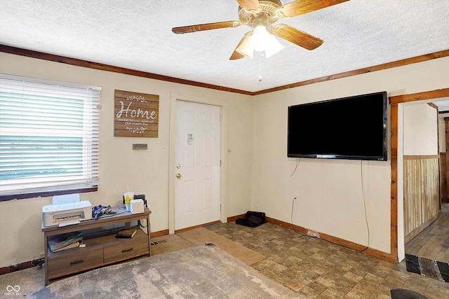 entrance foyer featuring ceiling fan, ornamental molding, and a textured ceiling