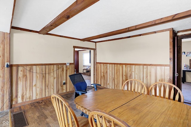 dining space featuring hardwood / wood-style floors and beam ceiling