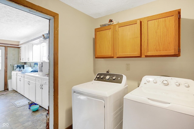 washroom featuring cabinets, washer and dryer, and a textured ceiling