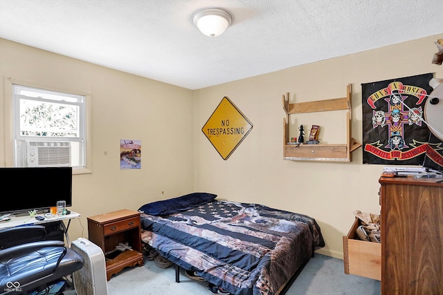 bedroom with cooling unit, light carpet, and a textured ceiling