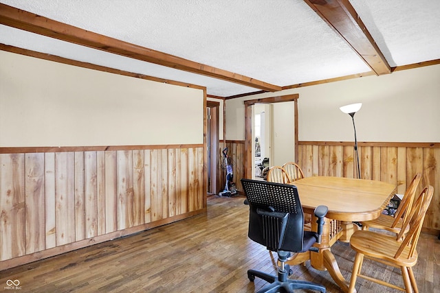 dining area featuring crown molding, beam ceiling, hardwood / wood-style floors, and a textured ceiling