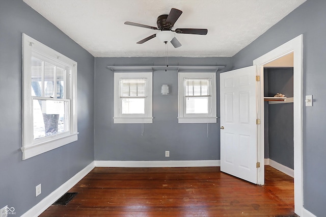 unfurnished room with ceiling fan and dark hardwood / wood-style floors