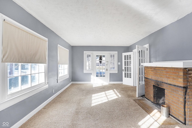 carpeted living room featuring a fireplace and a textured ceiling